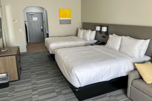 a hotel room with two beds and a couch at Comfort Inn & Suites in Lubbock