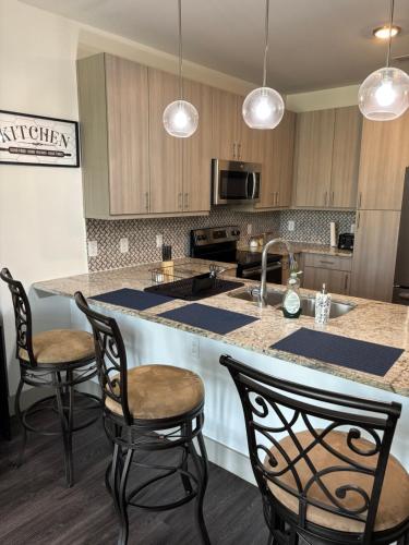 a kitchen with a counter with chairs and a sink at North Texas vacation get away! in The Colony