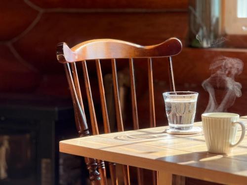a glass of water sitting on a table with a cup at Private Log villa 星空で北海道を楽しむ 新千歳空港から35分 エスコンから20分 in Naganuma