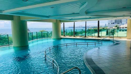 a large swimming pool in a building with windows at Whole Ocean View Manila Bay 4 Bedrooms in Manila