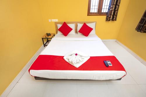- une chambre avec 2 lits dotés d'oreillers rouges et blancs dans l'établissement VMB Residency, à Pondichéry