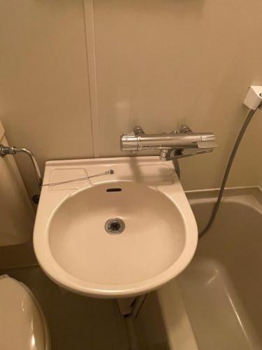 un baño con inodoro y lavabo en Popotel Three Room Z, en Matsumoto