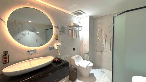 a bathroom with a sink and a large mirror at Trio Azana Style Kebumen in Kebumen