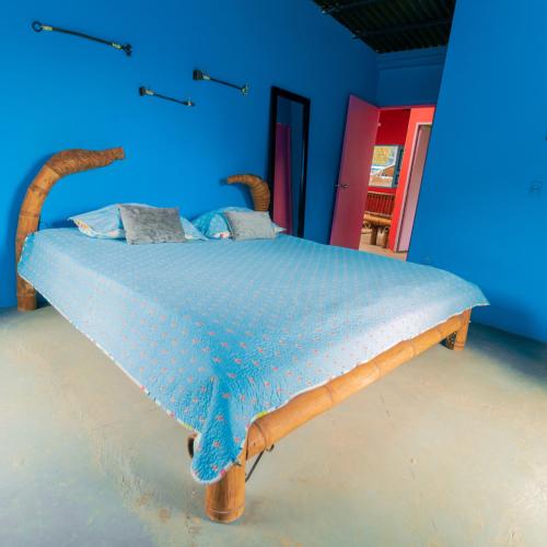 a bed in a blue room with a wooden frame at Victoria Ecolodge in Pereira
