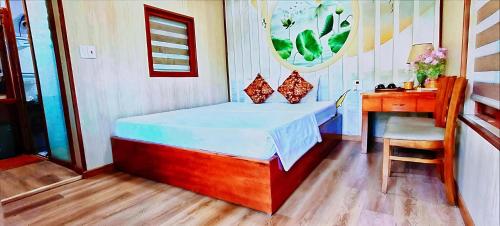 a small bedroom with a bed and a desk at Hang Mua Eco Garden in Xuân Sơn