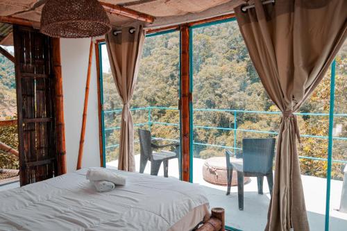 a bedroom with a bed and a large window at Victoria Ecolodge in Pereira
