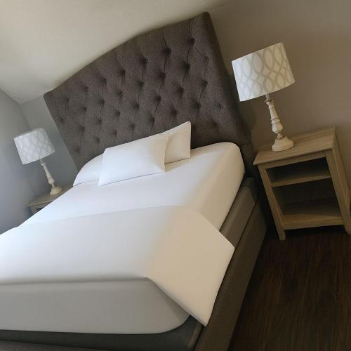a bedroom with a large bed and two lamps on tables at Luxury home 4BR, Pool, & 5 Mins to 401 in Whitby