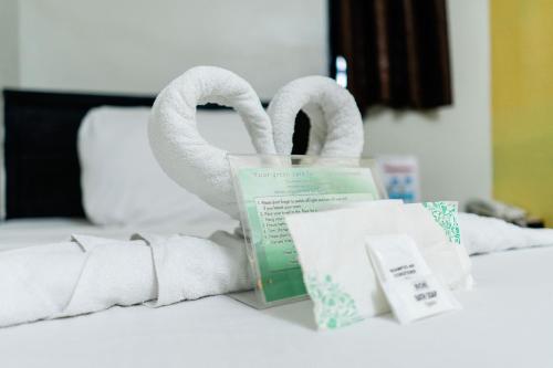 a pile of toilet paper and towels on a bed at Aikiko House in Davao City
