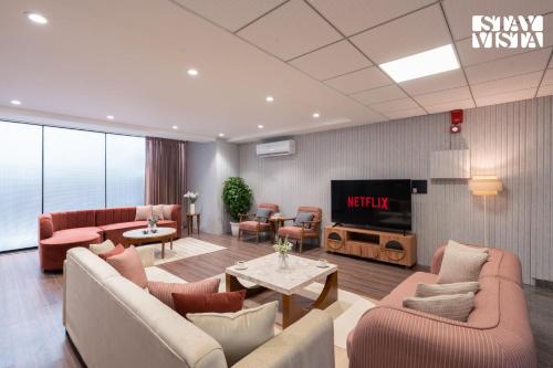 a lobby with a waiting room with furniture and a tv at StayVista Residences near Cyber City Hub with Gym & Air Purifier in Gurgaon