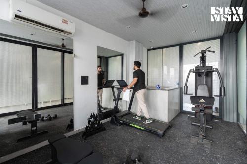 a man exercising on a treadmill in a gym at StayVista Residences near Cyber City Hub with Gym & Air Purifier in Gurgaon