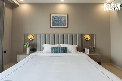 a bedroom with a large white bed with two pillows at StayVista Residences near Cyber City Hub with Gym & Air Purifier in Gurgaon