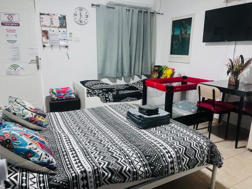 a room with a bed and a table and a desk at The Lowest Place on Earth B&B in Neʼot HaKikar