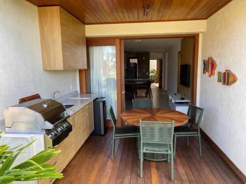 a kitchen with a table and chairs on a deck at Villaggio Super Aconchegante in Marau