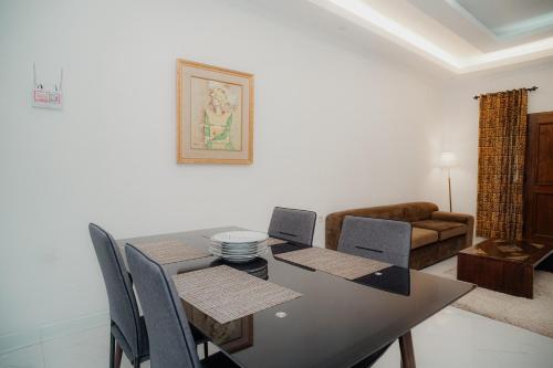 a dining room with a table and chairs and a couch at Illusion Homestay in Ngaglik
