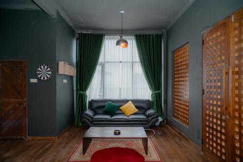 a living room with a couch and a window at Illusion Homestay in Ngaglik