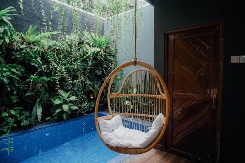 a swinging chair in a room with a garden at Illusion Homestay in Ngaglik