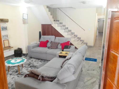 a living room with a couch and a staircase at Acomodação aconchegante COP-30 Belém in Belém