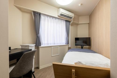 a bedroom with a bed and a desk and a window at Sleep Inn Gotanda in Tokyo
