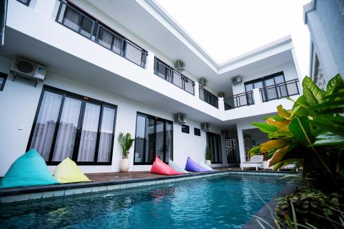 a house with a swimming pool with colorful pillows around it at Serenity Uluwatu in Uluwatu
