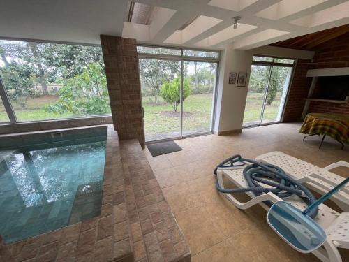 a living room with a swimming pool and chairs at Hermosa casa campestre rodeada de naturaleza y comodidad in Malchinguí