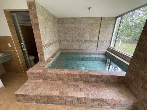 a jacuzzi tub in a room with a window at Hermosa casa campestre rodeada de naturaleza y comodidad in Malchinguí
