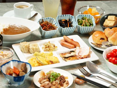 a table with plates of food and bowls of food at Hotel Brighton City Osaka Kitahama in Osaka