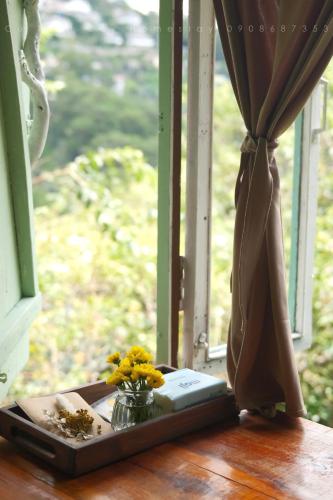 a vase of flowers sitting on a window sill at Cú Trên Cây Homestay in Xuan An