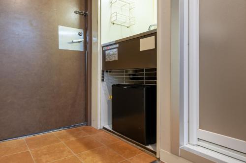 a kitchen with a black oven in a room at Sleep Inn Gotanda in Tokyo