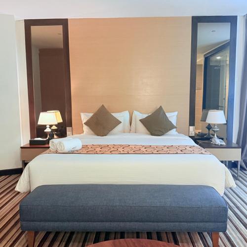 a large bed in a hotel room with two lamps at The Pure Hotel Langkawi in Kuah