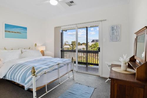 a bedroom with a bed and a balcony at Jacks Corner - 10 Marjory Street, Normanville in Normanville