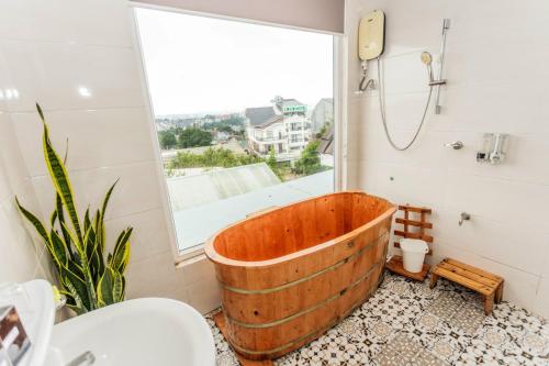 a wooden tub in a bathroom with a window at Tiên Hoa Sơn Villa in Da Lat