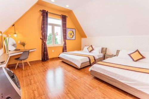 a hotel room with two beds and a desk at Tiên Hoa Sơn Villa in Da Lat