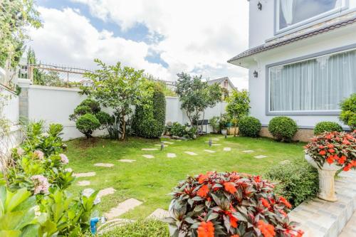 a garden with flowers and plants in front of a house at Tiên Hoa Sơn Villa in Da Lat