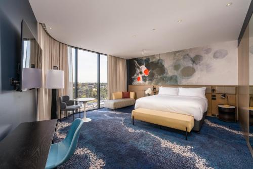 a hotel room with a bed and a desk at Novotel Sydney Cabramatta in Cabramatta