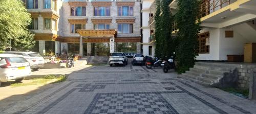 a street with cars parked in front of a building at MALIK PALACE leh in Leh