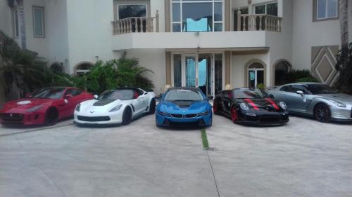 a group of four luxury cars parked in front of a building at La Mansión Residency Suites Ensenada in Ensenada