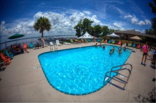 a large blue swimming pool with people in it at Crystal Cove Riverfront Resort in Palatka