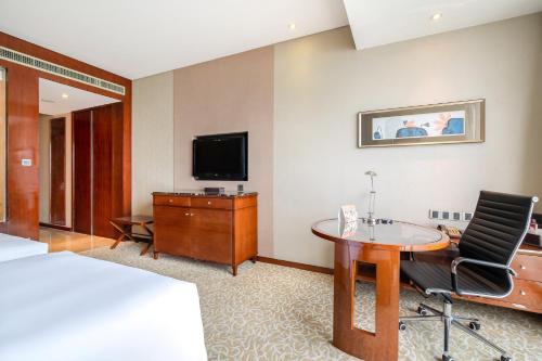 a hotel room with a bed and a desk and a tv at Crowne Plaza Zhenjiang by IHG in Zhenjiang