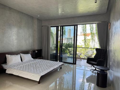 Un dormitorio con una cama y un balcón. en ZENVIRA POOL VILLA - Beach & Garden Retreat, en Nha Trang