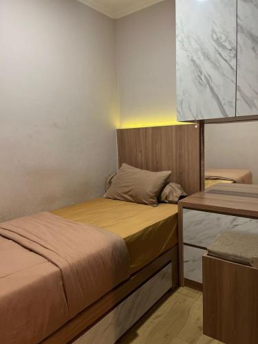 a bedroom with two beds and a table with a lamp at instaspace in Bandung