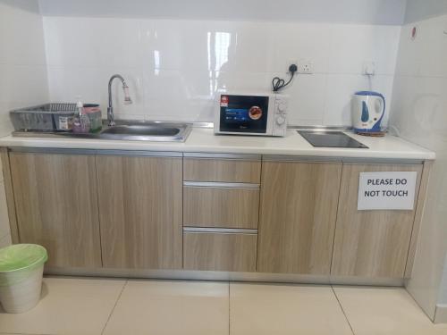a kitchen counter with a sink and a microwave at Core Soho Suit Kip Sentral Kotawarisan Family Studio Near KLIA & KLIA2 in Sepang