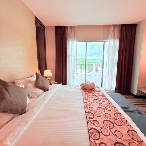 a large bed in a room with a large window at The Pure Hotel Langkawi in Kuah
