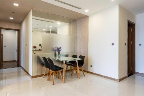 a dining room with a glass table and black chairs at Landmark Apartment City View in Kon Rung (1)