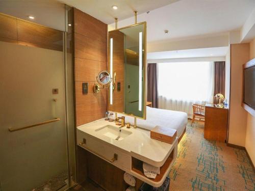 a bathroom with a bed and a sink and a shower at James Joyce Coffetel Changchun People's Square in Changchun