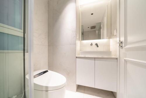 a white bathroom with a toilet and a sink at Urban Hub Superior Suite 3 bedrooms near the People's Square include Garden in Shanghai