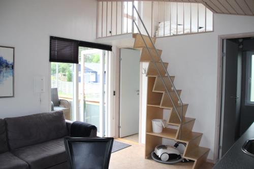 a living room with a staircase in a tiny house at Læsø Camping & Hytteby in Vesterø Havn
