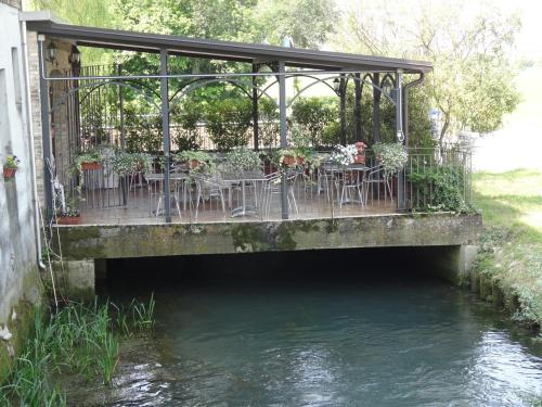 a bridge with tables and chairs next to a river at Cà Francine in Gruaro