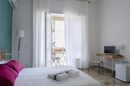 a white bedroom with a bed with towels on it at B&B Casa Rosellina in Palermo
