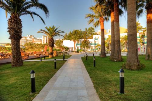 a walkway in a park with palm trees at Le Bleu Hotel & Resort Kusadasi in Kusadası