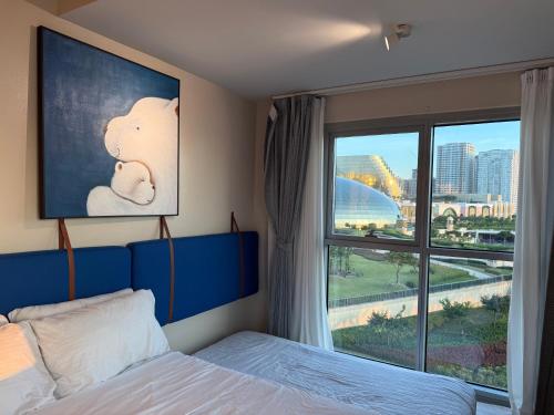 a bedroom with a bed and a large window at Modern 1BR with Balcony Facing Infinity Pool Manila Bay Sunset Near Airports OKADA Solaire MOA in Manila